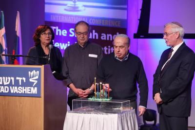 Jewish Agency Chairman Natan Sharansky lights a menorah created at a DP camp after the war
